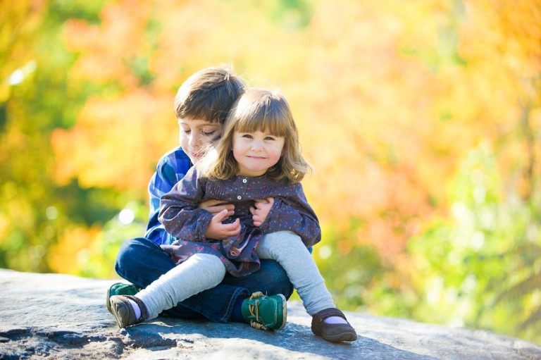 Siblings hug on a rock in a photoshoot in El Dorado Hills