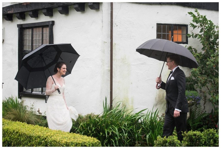 On a rainy day, a bride and groom see each other for the first time with big smiles.